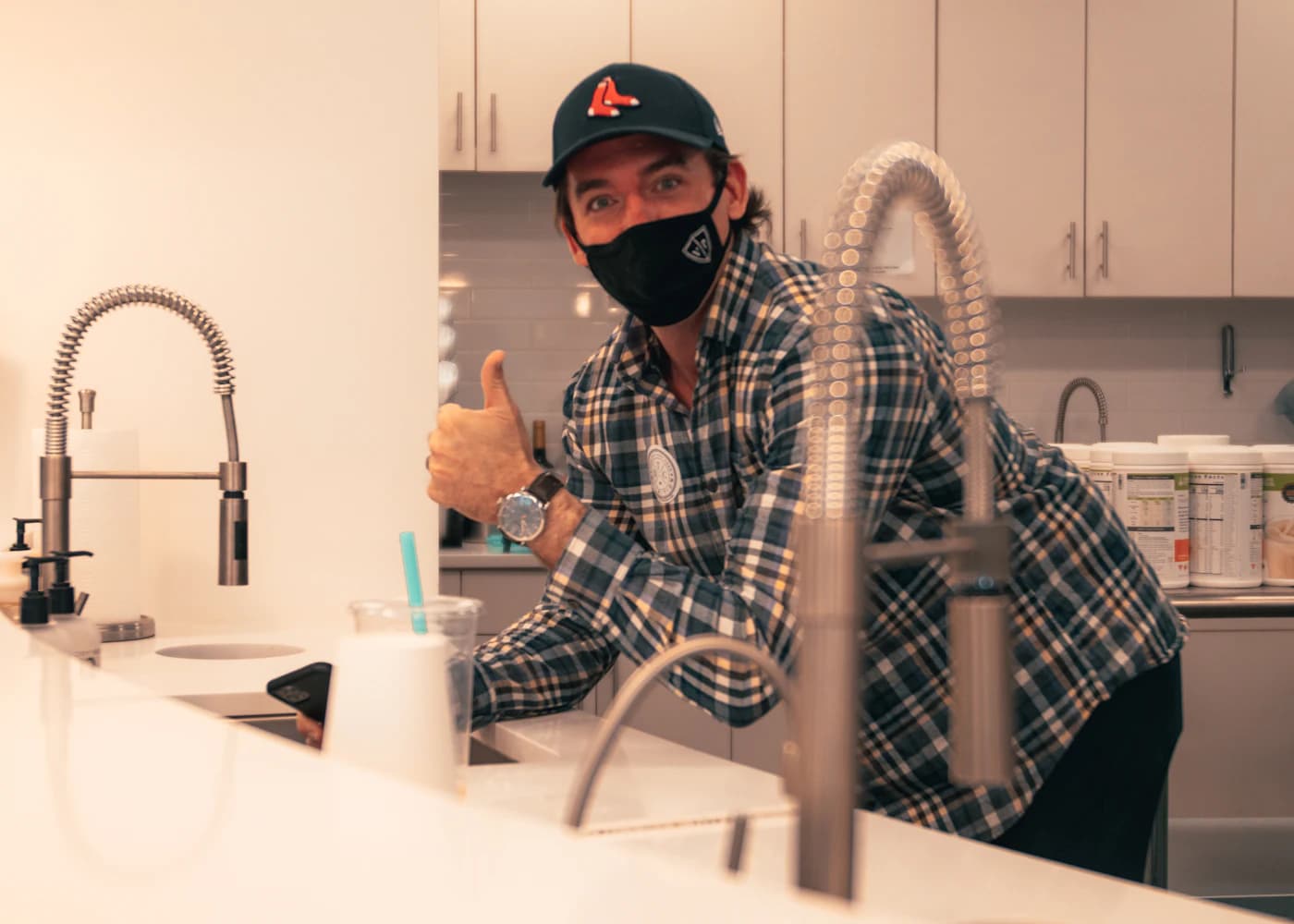 Plumber repairing pipework below a kitchen sink